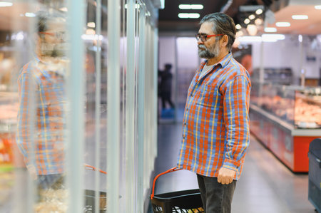 Senior man at grocery store products.の写真素材