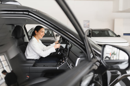 Young woman choosing a car at car showroom.の写真素材