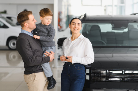 Family in a car dealership. Happy family came to an agreement with a car salesperson at a meeting in a showroom. Happy family choosing a new car in a showroomの写真素材