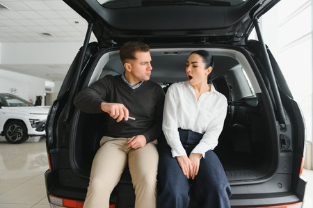 Couple checking new luxury cars at dealership automobile salon.