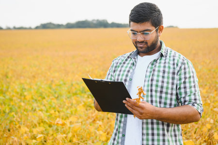 A young Indian farmer works in a soybean field.