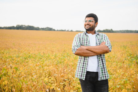 A young Indian farmer works in a soybean field.の写真素材