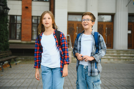 Happy children near the school. Friends boy and girl together in the school yard.の写真素材