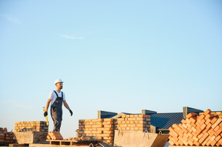 Construction worker in uniform and safety equipment have job on building.