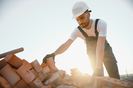 Construction worker in uniform and safety equipment have job on building.