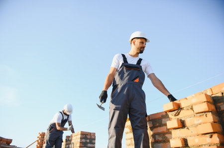 Man bricklayer installing bricks on construction site.の写真素材
