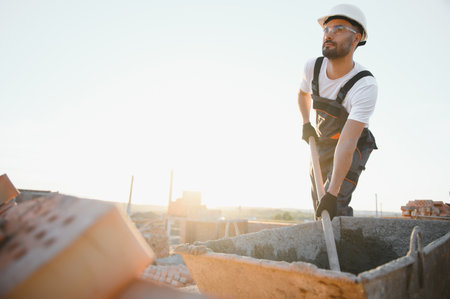 Construction worker in uniform and safety equipment have job on building.