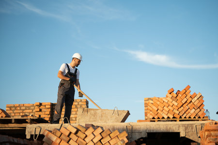 Man bricklayer installing bricks on construction site.の写真素材