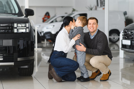 Young happy family enjoying while buying a new car in a showroom.の写真素材