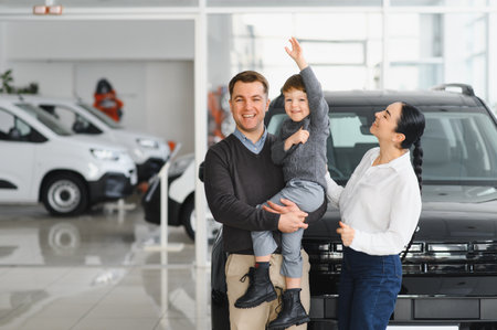Young happy family enjoying while buying a new car in a showroom.の写真素材