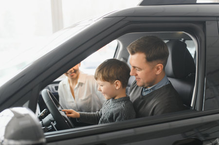 Family in a car dealership. Happy family came to an agreement with a car salesperson at a meeting in a showroom. Happy family choosing a new car in a showroomの写真素材