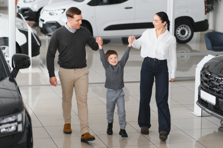 Family in a car dealership. Happy family came to an agreement with a car salesperson at a meeting in a showroom. Happy family choosing a new car in a showroomの写真素材