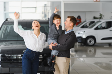Young happy family enjoying while buying a new car in a showroom.の写真素材