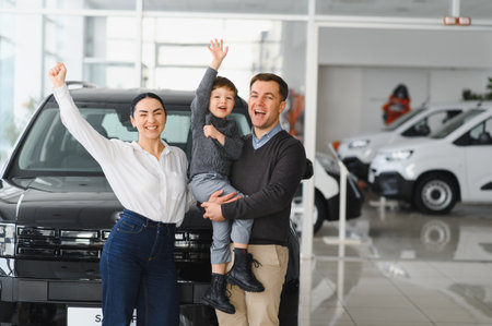 Family in a car dealership. Happy family came to an agreement with a car salesperson at a meeting in a showroom. Happy family choosing a new car in a showroomの写真素材