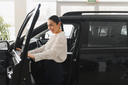 Young woman choosing a car at car showroom.