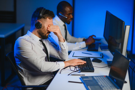 Happy Confident Technical Customer Support Specialist Having a Headset Call in a Monitoring and Control Room Filled with Colleagues and Display Screens.の写真素材
