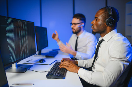 Happy Confident Technical Customer Support Specialist Having a Headset Call in a Monitoring and Control Room Filled with Colleagues and Display Screens.の写真素材