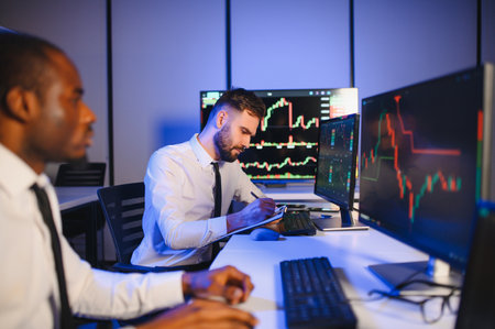 Team of traders working at monitor computer and browsing online in trading office.