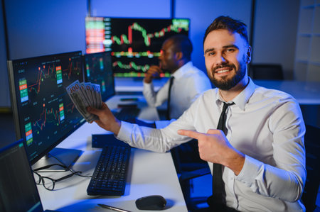Conception of teamwork. Team of stockbrokers works in modern office with many display screens.