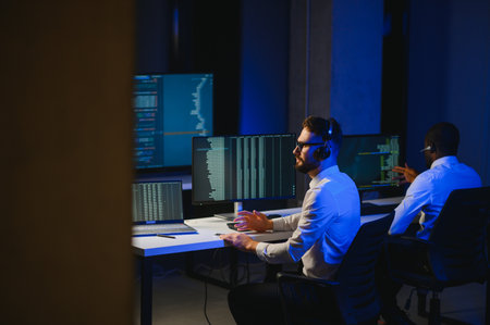 Happy Confident Technical Customer Support Specialist Having a Headset Call in a Monitoring and Control Room Filled with Colleagues and Display Screens.の写真素材