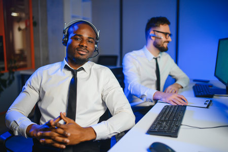 Center of dispatching maintenance. Waist up side on of young Afro-American males working on air navigation controller boardの写真素材