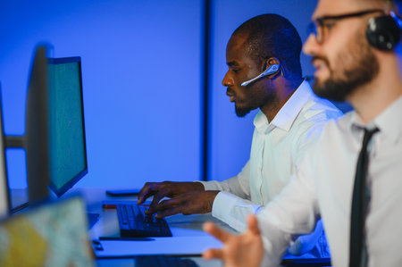 Diverse call center operators team use computers consulting clients in office.