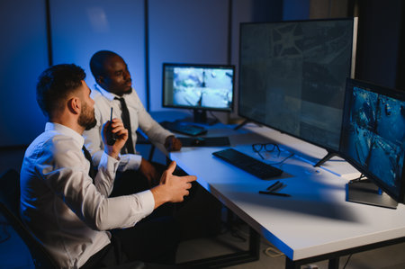 Two male security guards looking at computer screen while one of them explaining detail of video.の写真素材