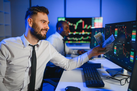 Conception of teamwork. Team of stockbrokers works in modern office with many display screens.
