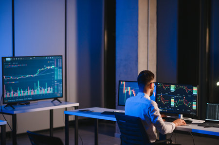 Crypto trader investor analyst looking at computer screen analyzing financial graph data on pc monitor, thinking of online stock exchange market trading investment global risks, over shoulder view.の写真素材