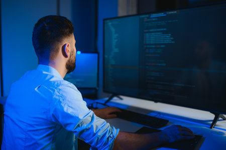 IT Programmer Working on Desktop Computer. Male Specialist Creating Innovative Software Engineer Developing App, Program, Video Game. Terminal with Coding Language. Over Shoulderの写真素材
