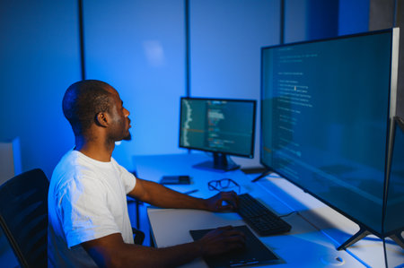 Portrait of African American male programmer in office at night.