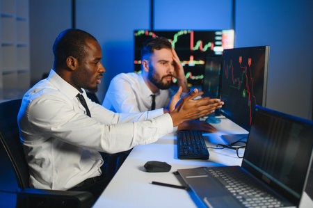Conception of teamwork. Team of stockbrokers works in modern office with many display screens.の写真素材