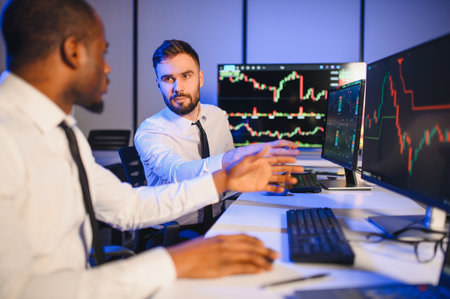 Conception of teamwork. Team of stockbrokers works in modern office with many display screens.