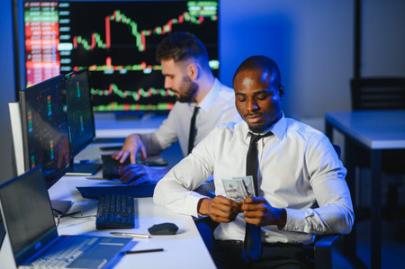 Team of traders working at monitor computer and browsing online in trading office.の写真素材