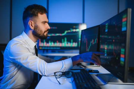 Financial Analyst Working on a Computer with Multi Monitor Workstation with Real Time Stocks.