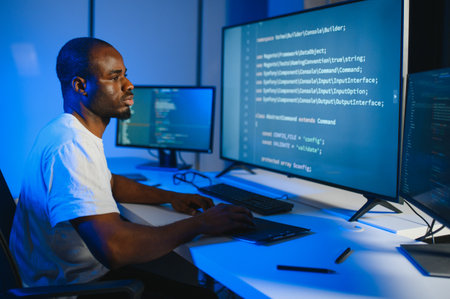 Portrait of African American male programmer in office at night.の写真素材