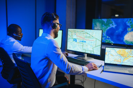 Center of dispatching maintenance. Portrait of men working via headset microphone while sitting on...