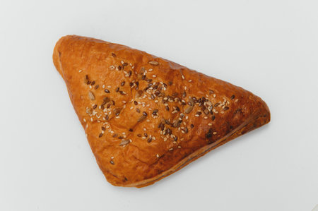 Puff pastry triangle filled with meat on white background.の写真素材