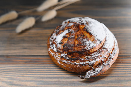 Sweet cinnamon bun roll swirl on a wooden background.の写真素材