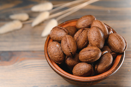 Delicious nut shaped cookies with boiled condensed milk on a wooden background.