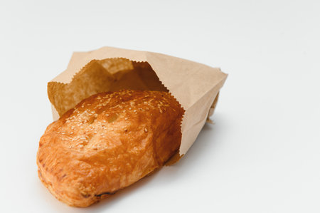 Brazilian pastry packed in brown paper on a white background.の写真素材