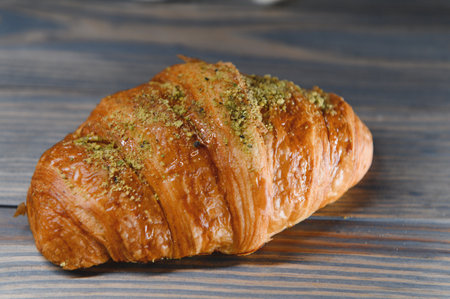 fresh baked croissant isolated on a wooden background.の写真素材