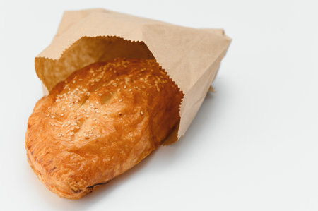 Brazilian pastry packed in brown paper on a white background.