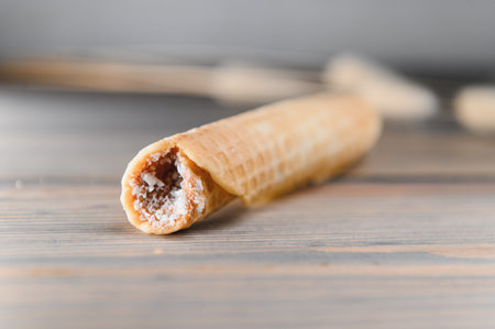 Delicious wafer rolls with boiled condensed milk on a wooden background.の写真素材