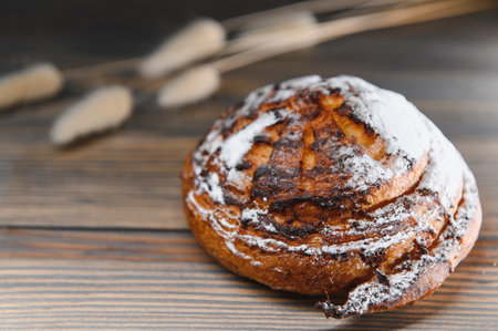 Sweet cinnamon bun roll swirl on a wooden background.の写真素材