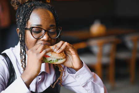 african american woman with vegan meatless burger meal.の写真素材