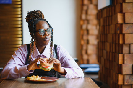 african american woman with vegan meatless burger meal.の写真素材