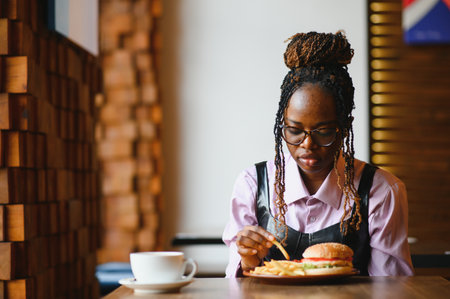 african american woman with vegan meatless burger meal.の写真素材
