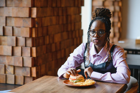 african american woman with vegan meatless burger meal.の写真素材