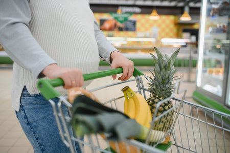 Pregnant woman choosing and buying food in supermarket.の写真素材